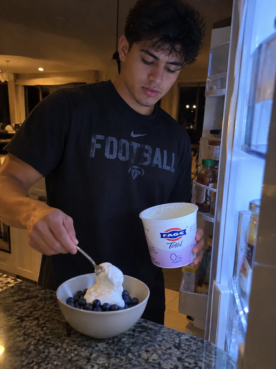 Athlete preparing a bowl of blueberries with plain Greek yogurt at home